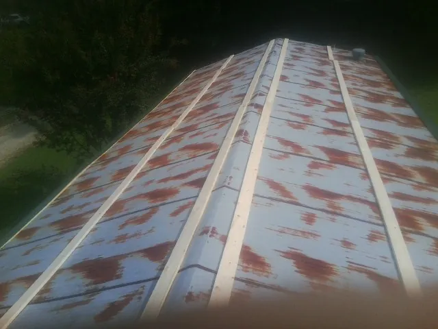 Rusted metal roof panels with new wood purlins before replacement — Storm Damage Roof Repair in Joliet by Roofing Brothers
