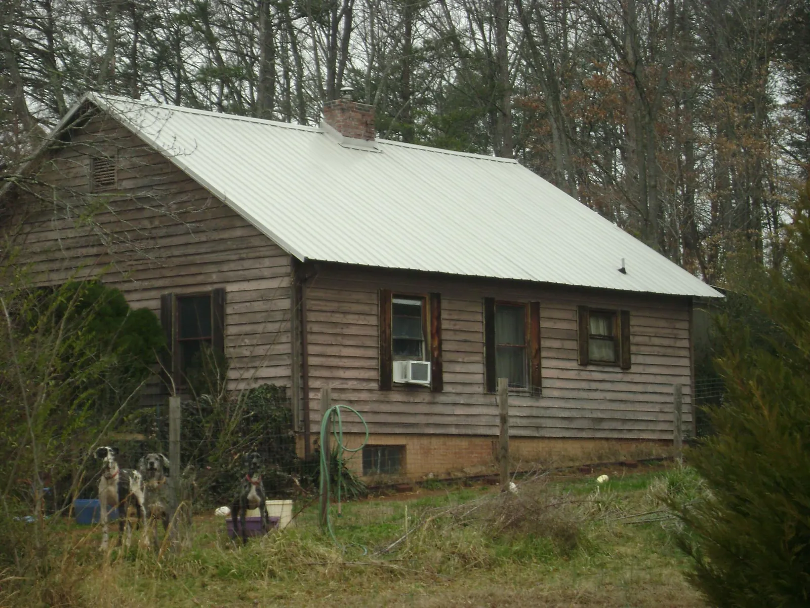White metal roof on an old wood sided farmhouse, from a Metal Roof Installation job in Joliet